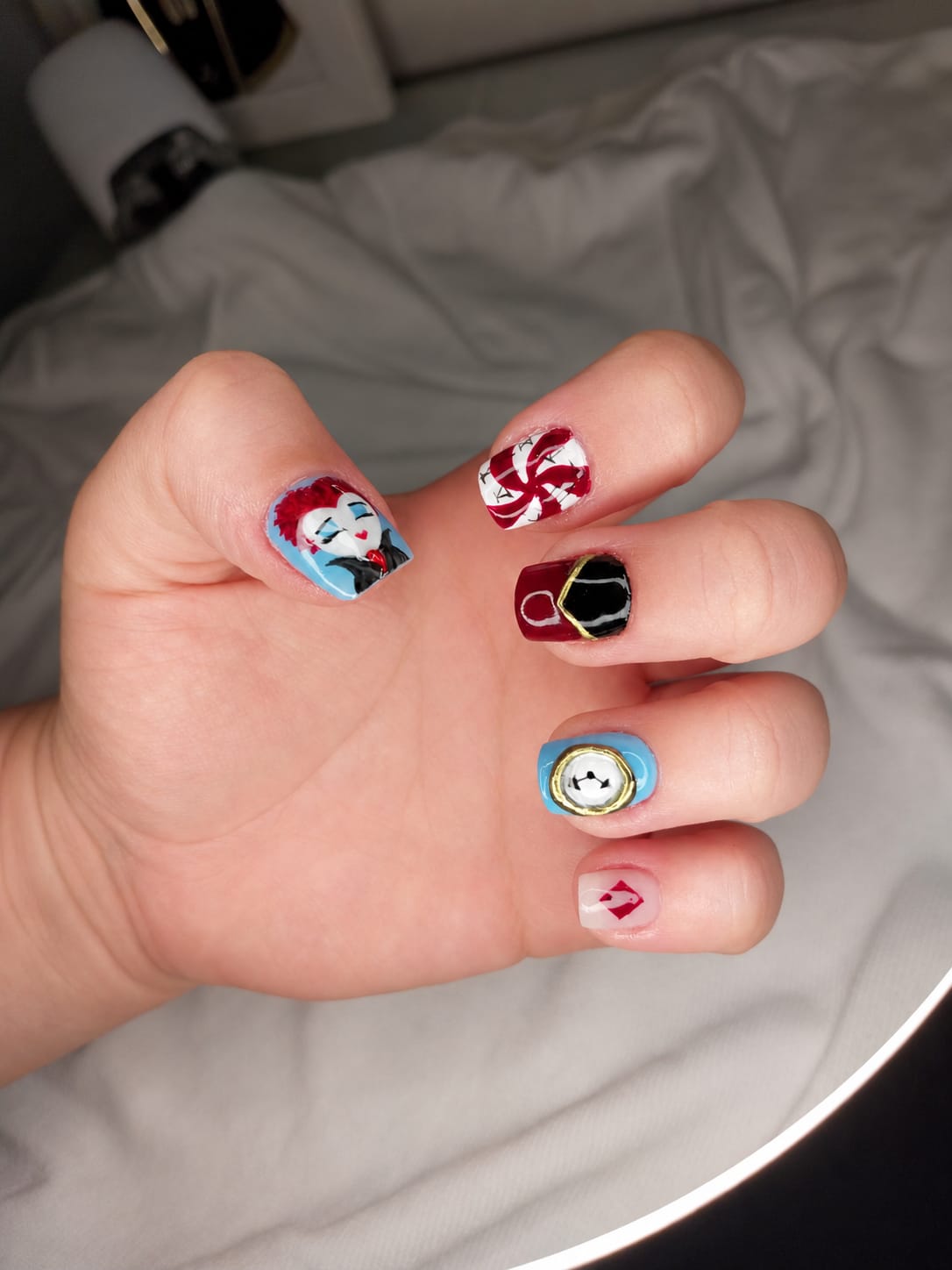 Unhas com nail art temática pintada à mão livre, com personagens e detalhes em vermelho e preto