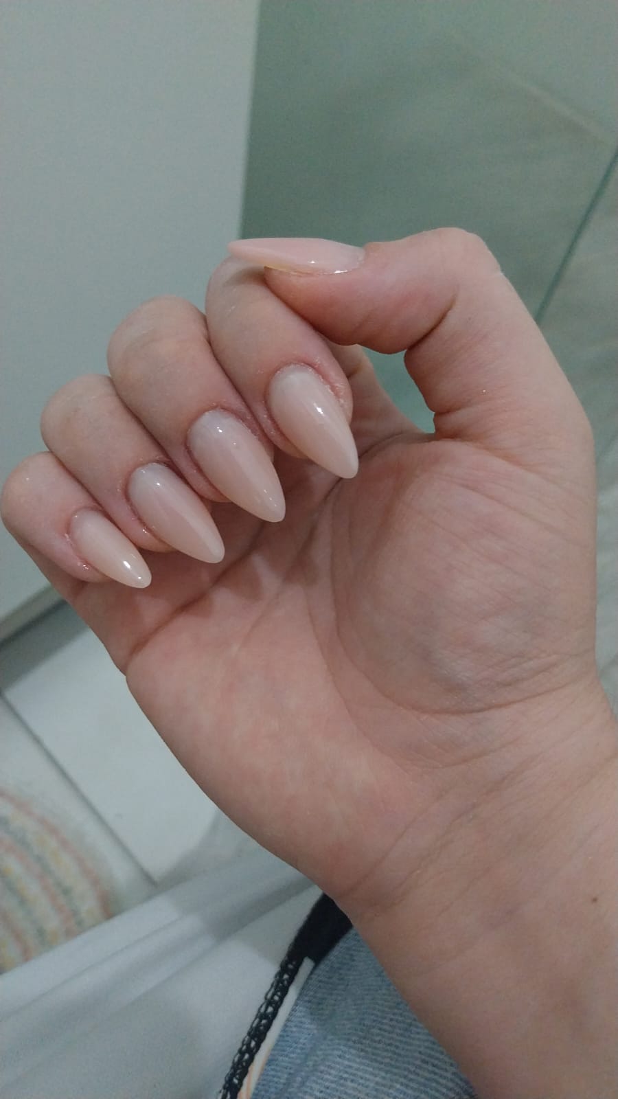Alongamento de unhas em formato stiletto com esmaltação nude natural